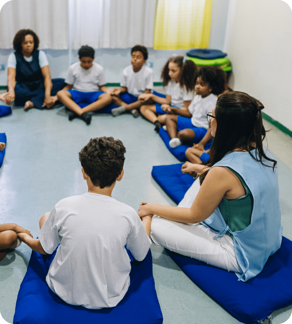 Children and teachers sitting in a circle.