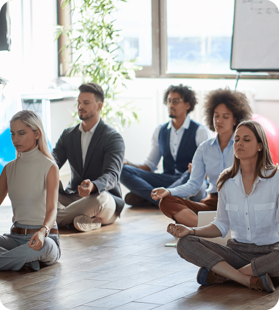Group meditating in office setting.