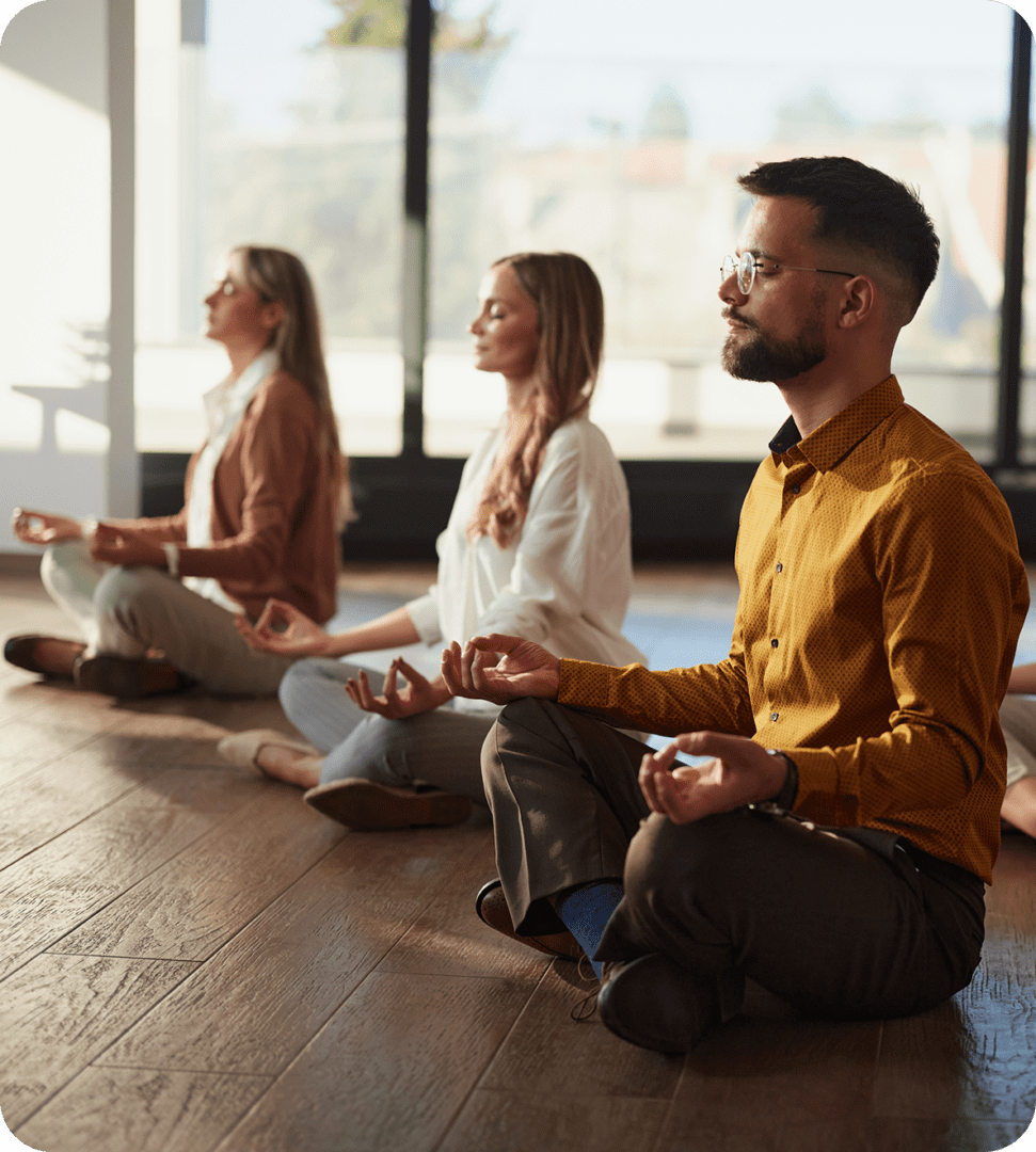 People meditating in a calm indoor setting.